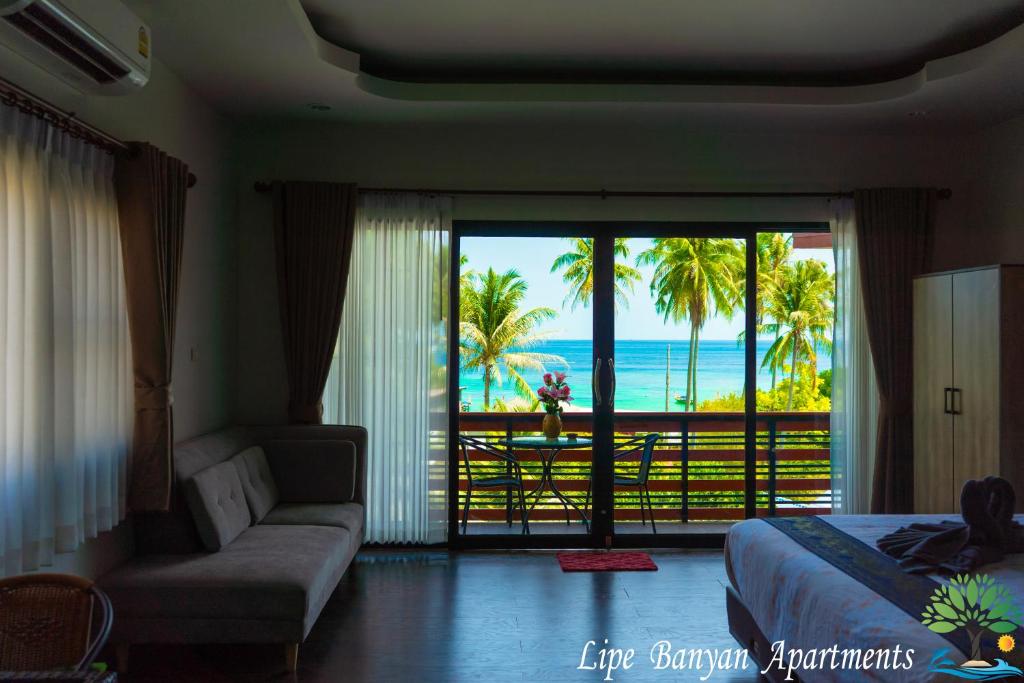a bedroom with a bed and a view of the ocean at Lipe Banyan Apartments in Ko Lipe
