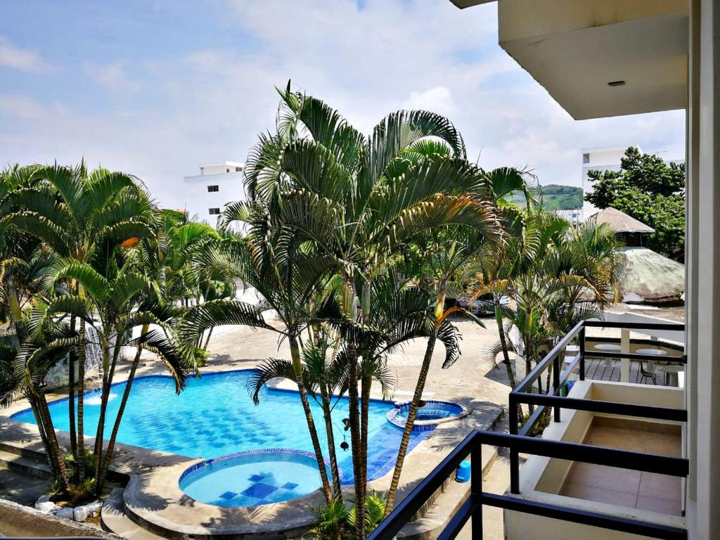 a view of a resort pool with palm trees at La Bocana in Tonsupa