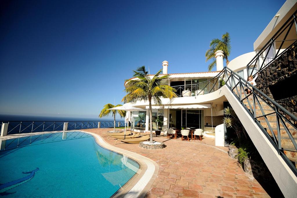 a house with a swimming pool next to the ocean at Villa Bahía in Sauzal
