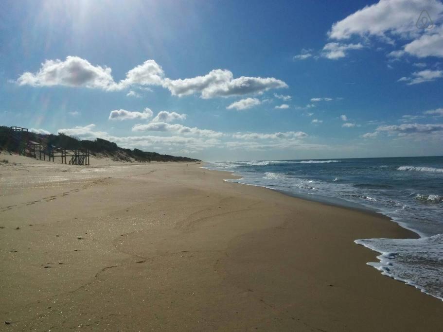 a sandy beach with the ocean and clouds in the sky at 90 Mile Beach Luxury Escape in Seaspray