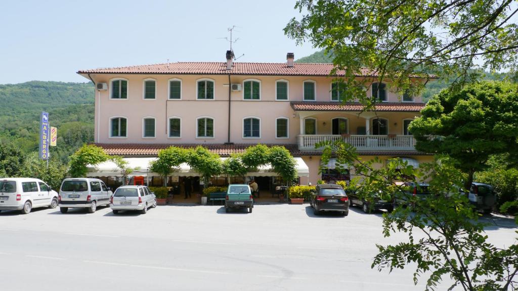 duży budynek z samochodami zaparkowanymi na parkingu w obiekcie Albergo Ristorante Sterlina w mieście Grizzana