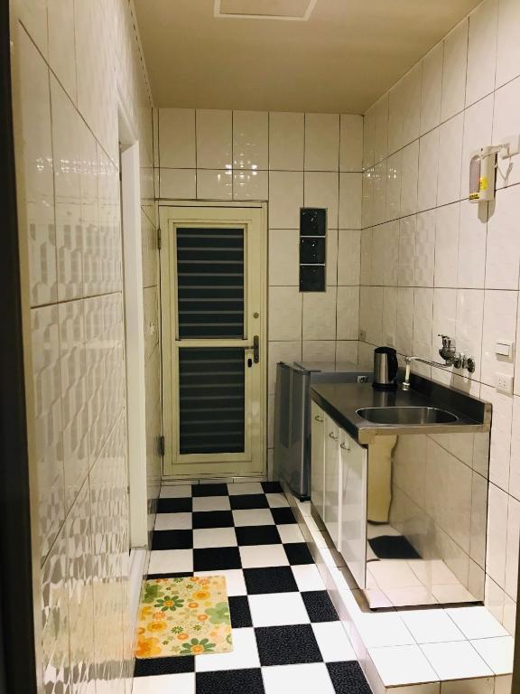 a kitchen with a black and white checkered floor at 橙橙民宿 in Ruifang