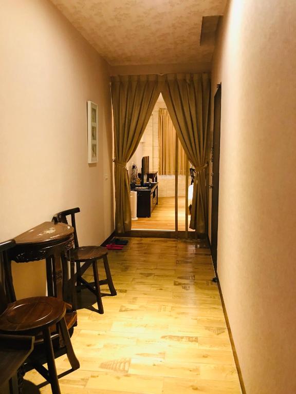 a hallway with a table and chairs and a room at 橙橙民宿 in Ruifang