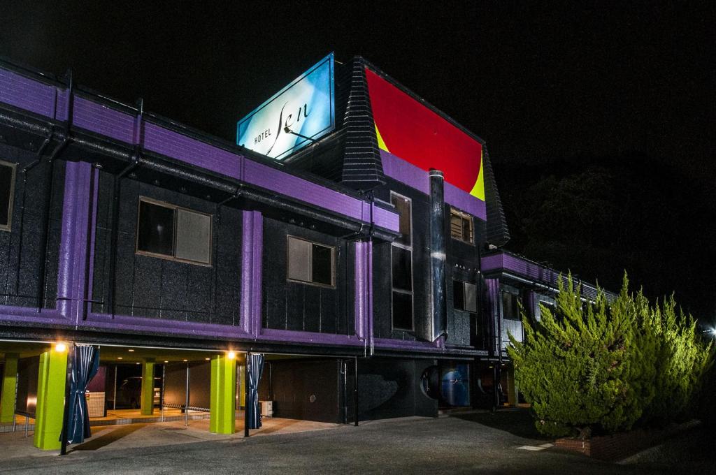 a building with a sign on the side of it at night at Hotel Sen (Love Hotel) in Mizumaki