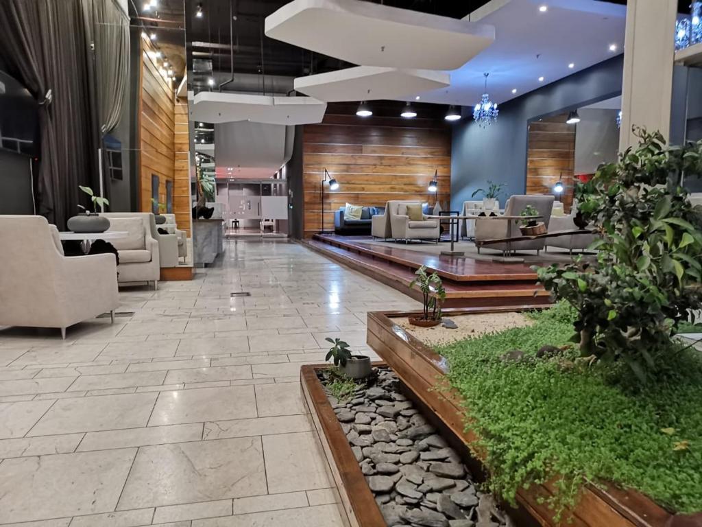 a lobby with couches and chairs and plants at The Franklin Luxury Apartments in Johannesburg