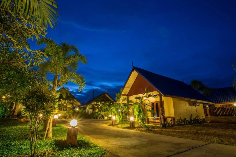 Family Resort Chumphon في شومفون: منزل فيه انوار على شارع بالليل