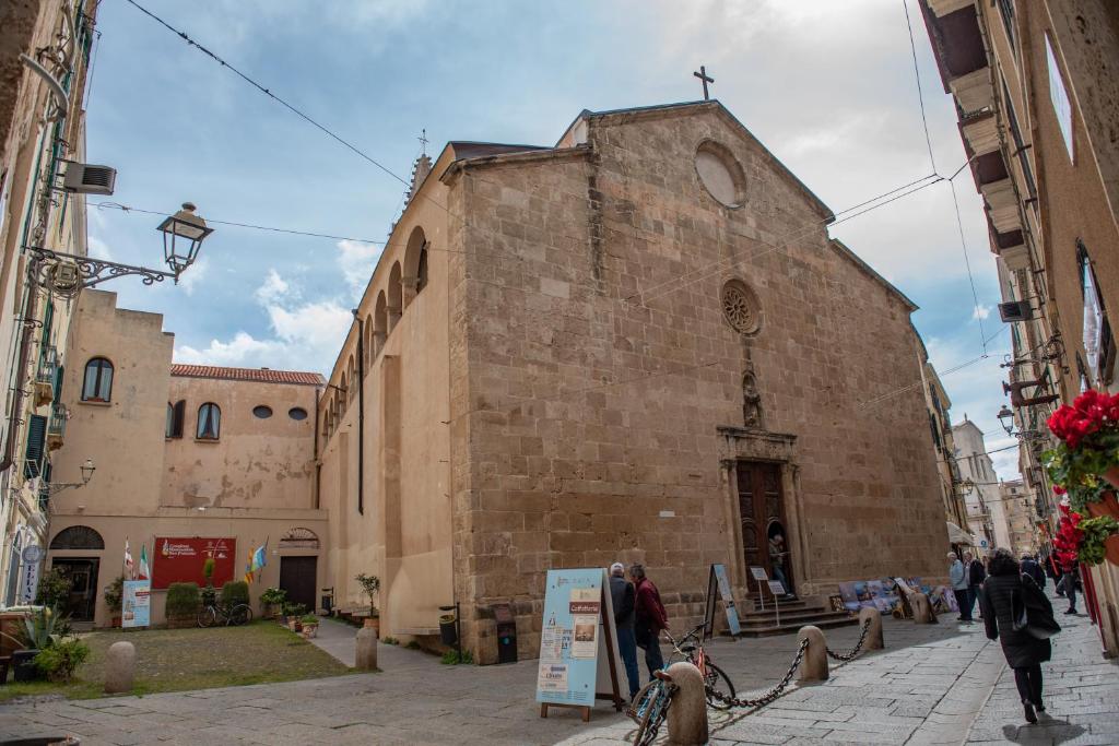 a large brick building with a cross on top of it at Centro Storico Carlo Alberto in Alghero