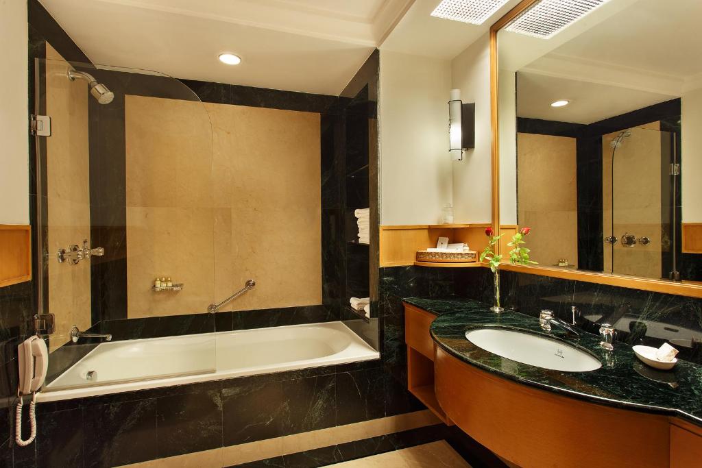 a bathroom with a bath tub and a sink at Trident Chennai in Chennai