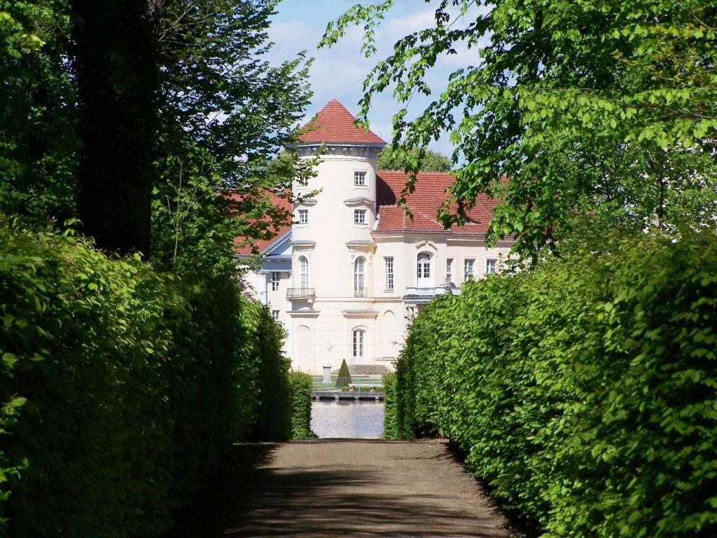 un gran edificio blanco con techo rojo en Marstall im Schlosspark Rheinsberg, en Rheinsberg