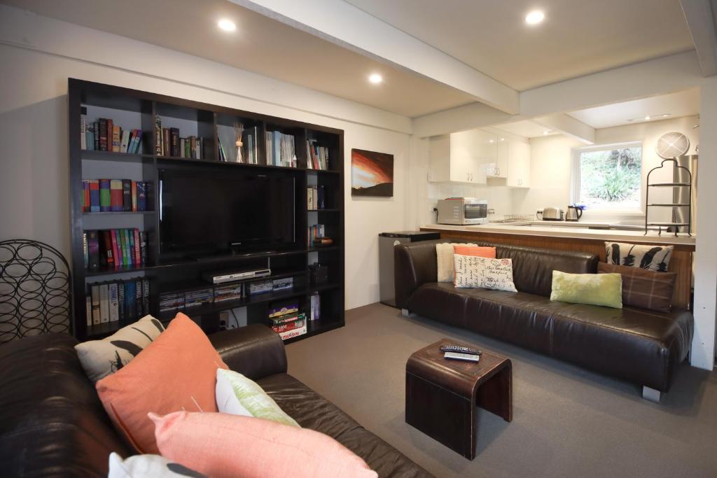 a living room with a couch and a tv at Maisonettes Falls Creek in Falls Creek