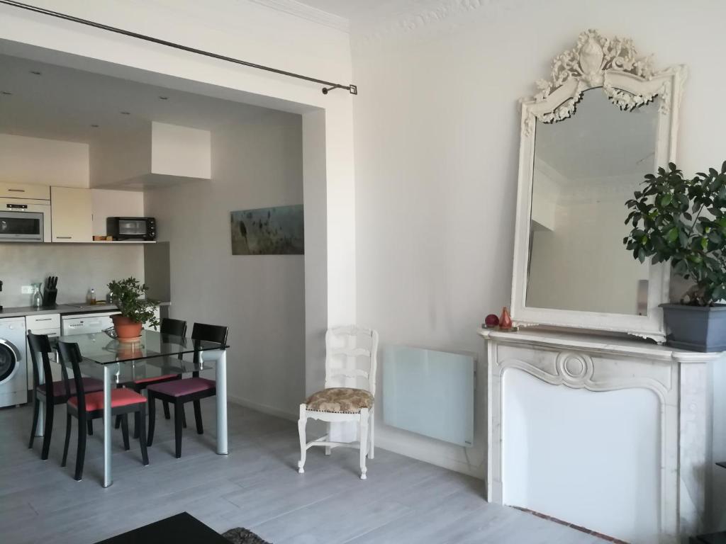 a dining room with a table and a mirror at 6 Rue de Castillon Appartement in Beausoleil