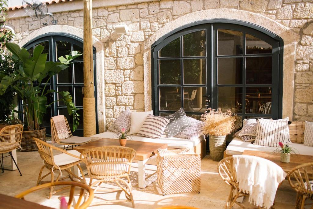 a patio with a couch and tables and chairs at GAIA ALAÇATI in Alaçatı