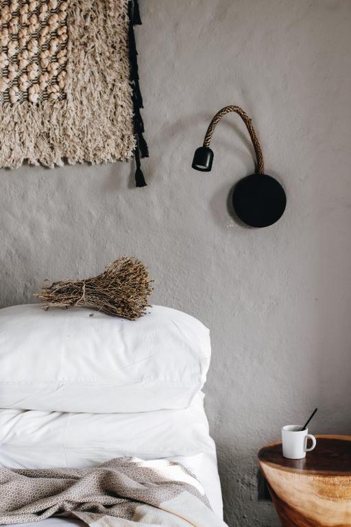 a bedroom with a bed with a lamp and a table at GAIA ALAÇATI in Alaçatı