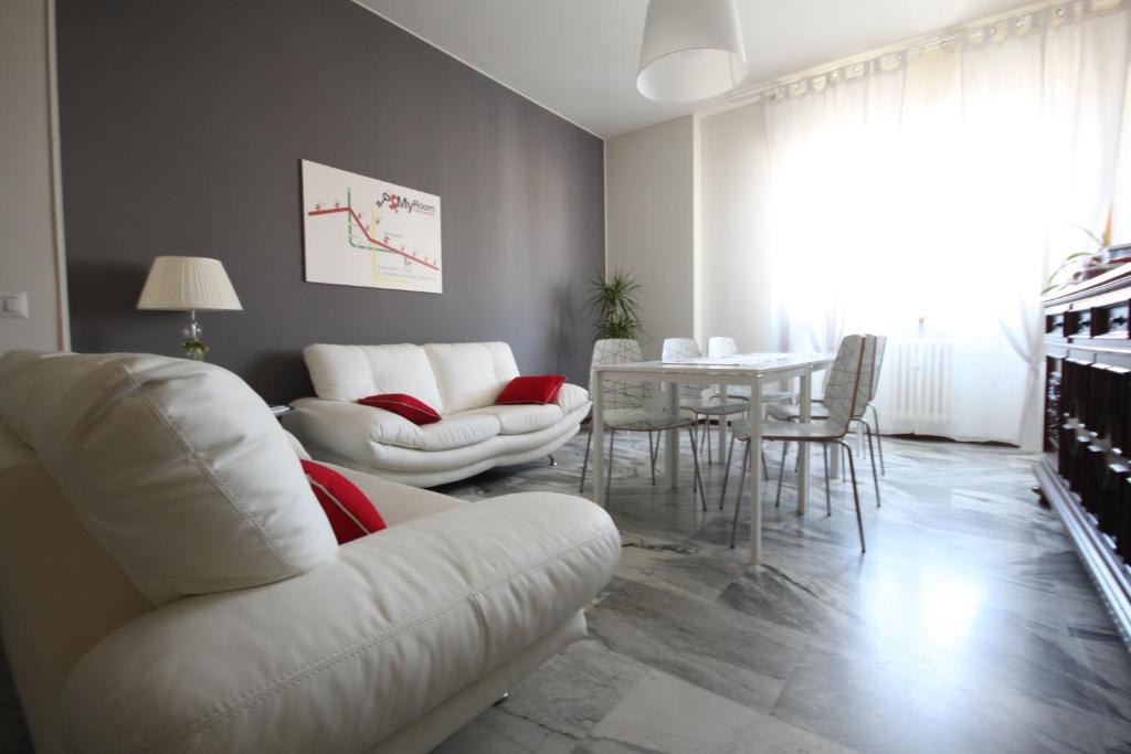 un soggiorno con divano bianco e tavolo di MyRoom In Town a Bergamo