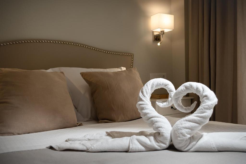 a bed with two swans made out of towels at Hostal Boutique Plaza Cantarero in Nerja