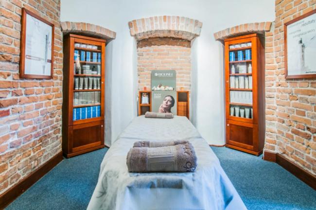 a bedroom with a bed in a brick room at Czerwony Dwór in Krynica Zdrój