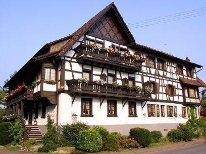 ein großes weißes Gebäude mit Balkonen und Blumen darauf in der Unterkunft Schwarzwaldhotel Stollen in Gutach im Breisgau