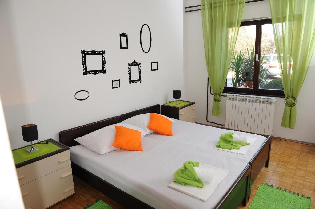 a bedroom with a bed with orange and green pillows at Ljubica Comfortable Apartment in Ploče