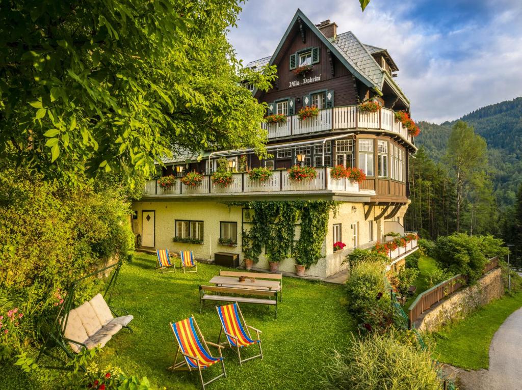 ein großes Haus mit Stühlen und einem Garten in der Unterkunft Villa Daheim Semmering in Semmering