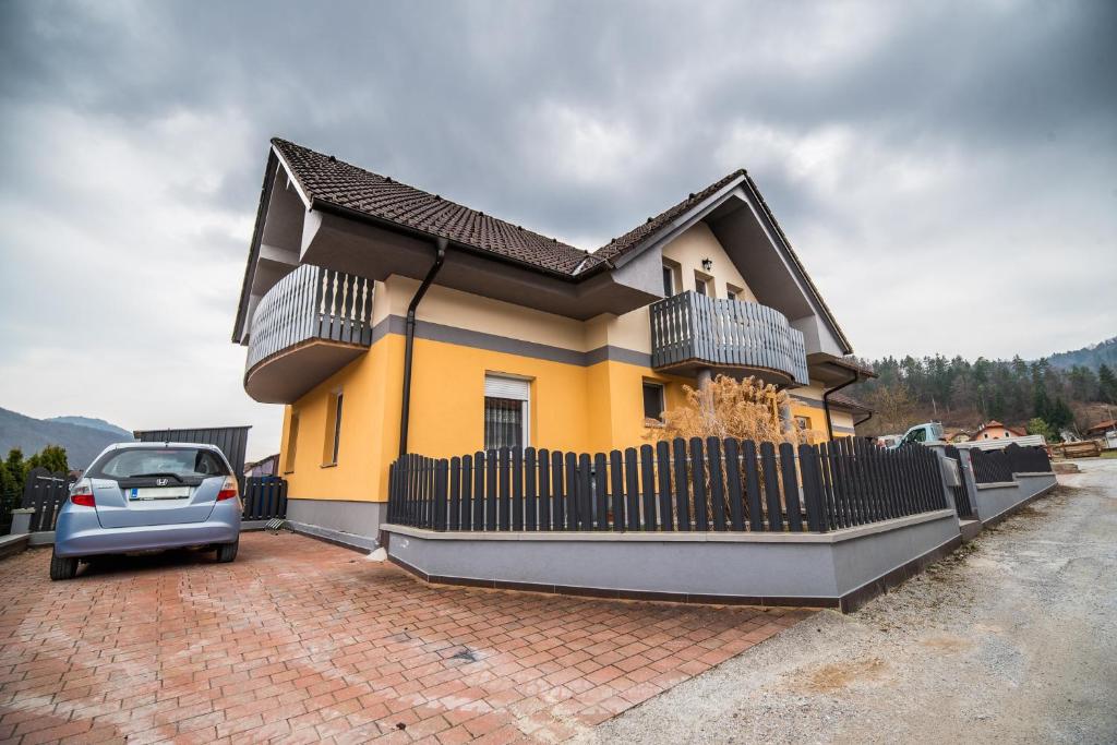 a house with a car parked in front of it at Apartment Želimlje in Škofljica