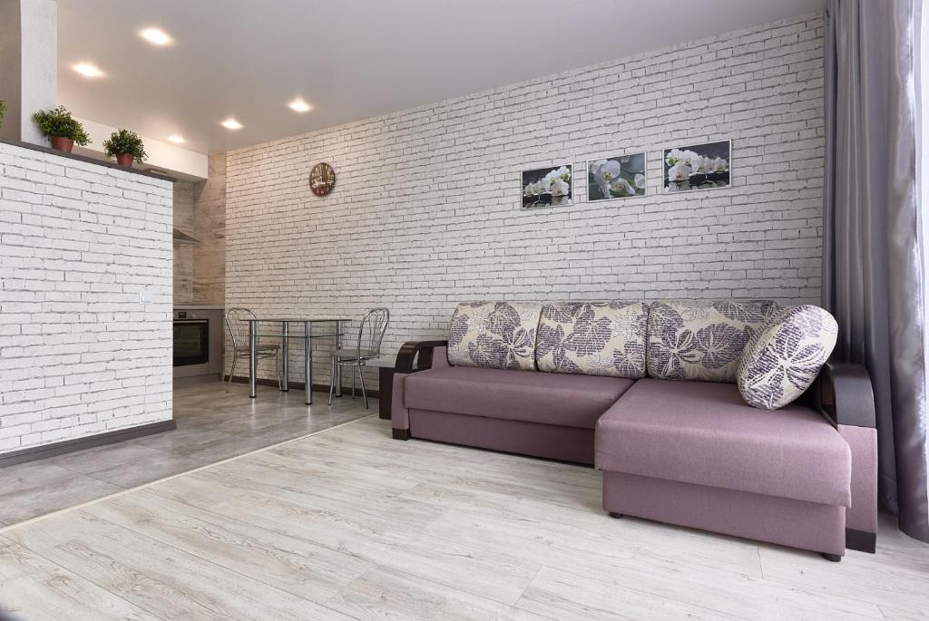 - un salon avec un canapé violet en face d'un mur de briques dans l'établissement Perfect apartments m Polytech, Ohmatdet, parking, à Kiev