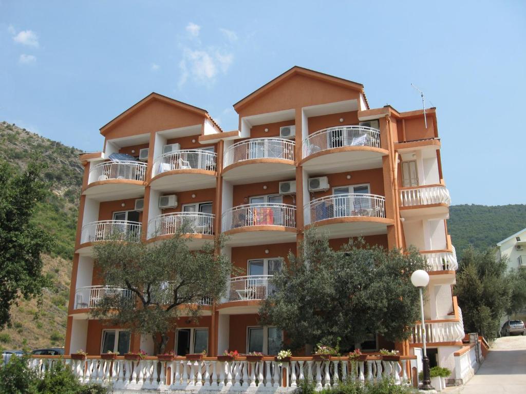 un gran edificio de apartamentos con balcones y árboles en Villa San Marco, en Budva