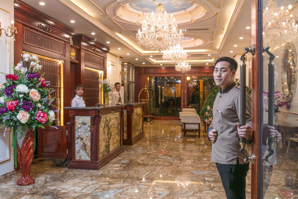 un hombre parado en el vestíbulo de un hotel en Royal St Hanoi Hotel, en Hanói