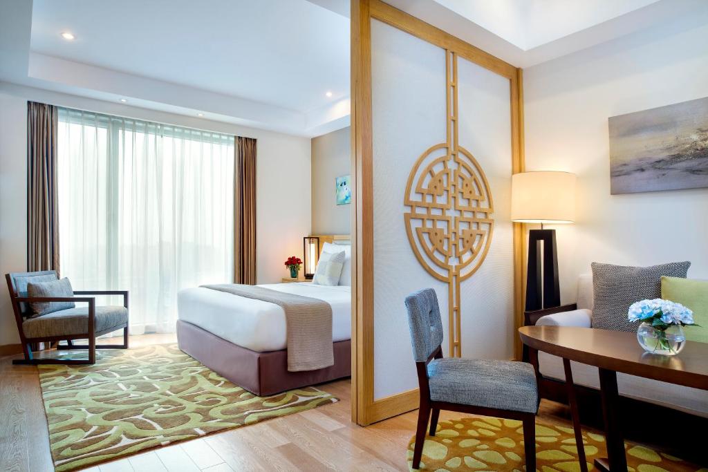 a hotel room with a bed and a desk and a table at Shama Heda Serviced Apartment in Hangzhou