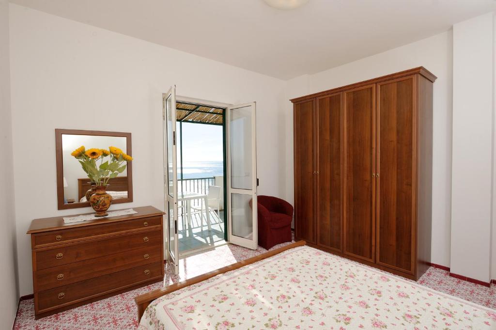 una camera con letto e comò con specchio di Amalfi Blue FLowers B ad Amalfi