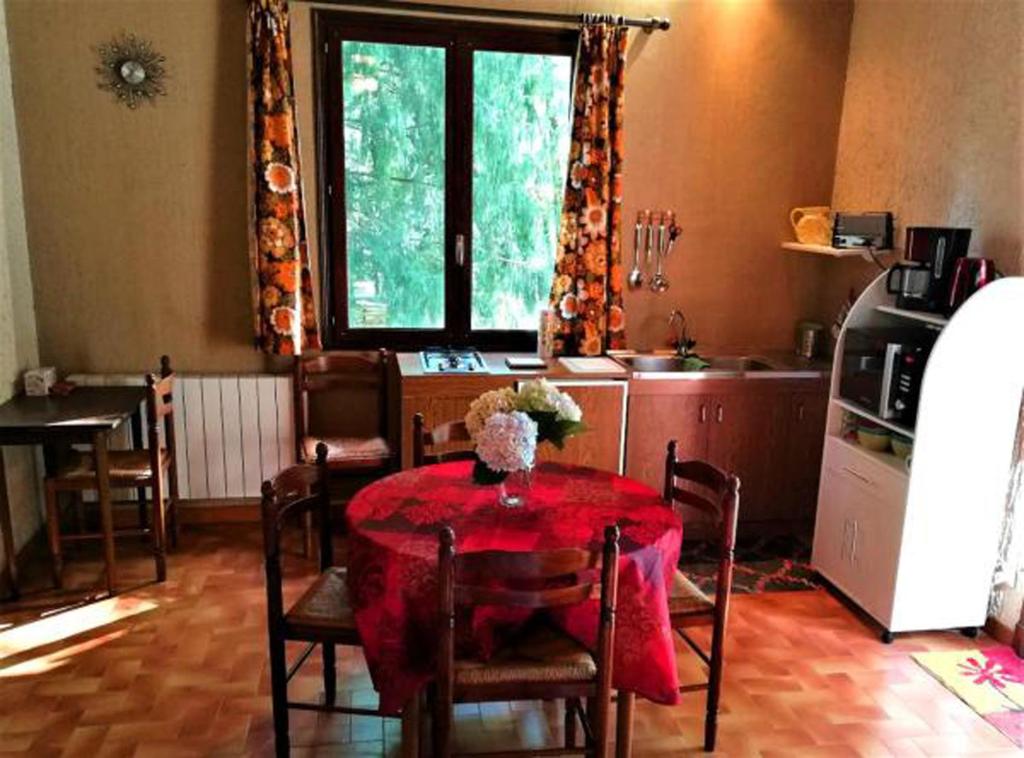 a kitchen with a table with a red table cloth at Studio duplex 2 Lac des Montagnès in Mazamet