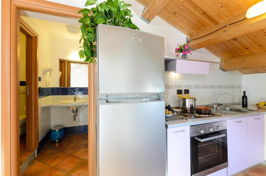 a kitchen with a white refrigerator and a sink at Le Tartarughe Aparthotel in Letojanni