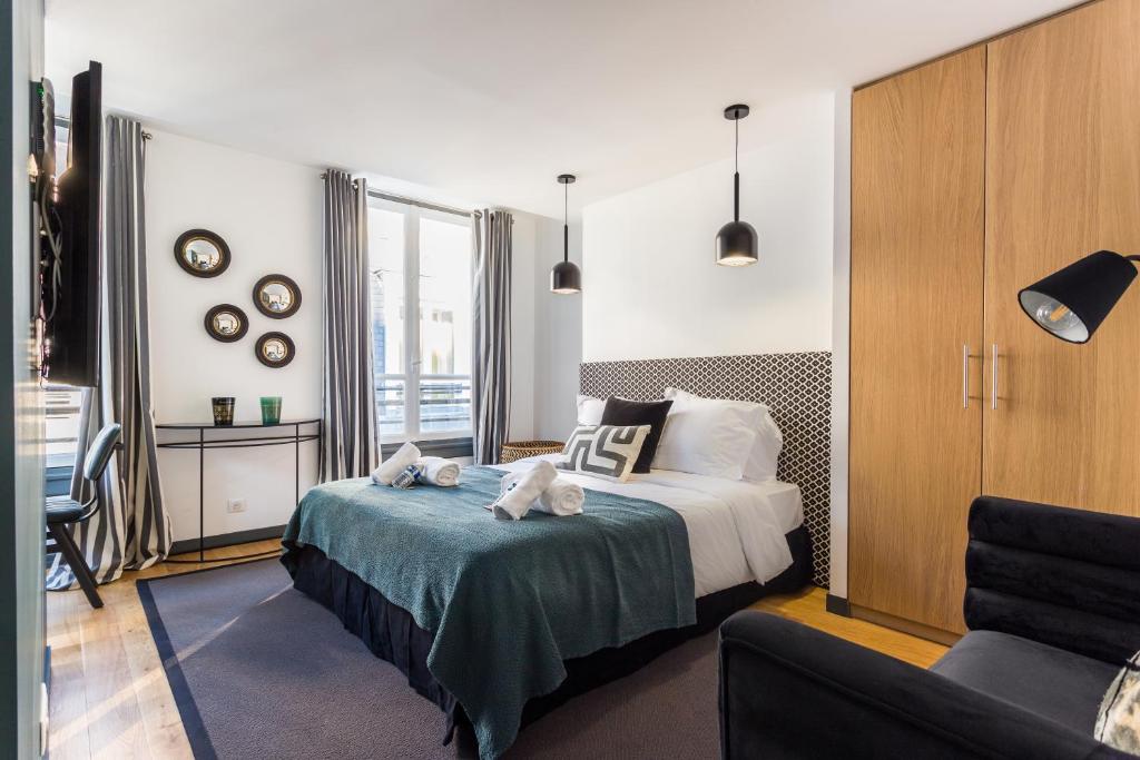 un dormitorio con una cama con dos animales de peluche en CMG Champs Elysées - Boetie 4DD, en París