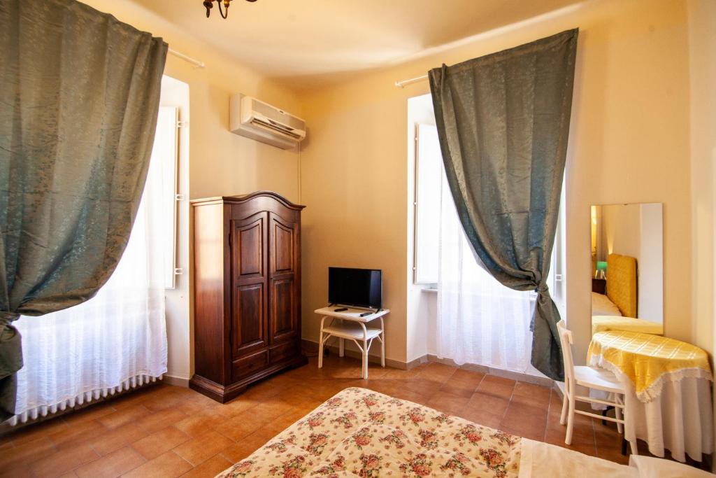 a room with a bedroom with a tv and curtains at Le Violette in Lucca