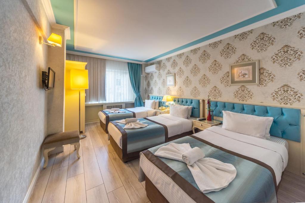 a hotel room with two beds and two lamps at Viva Deluxe Hotel in Istanbul