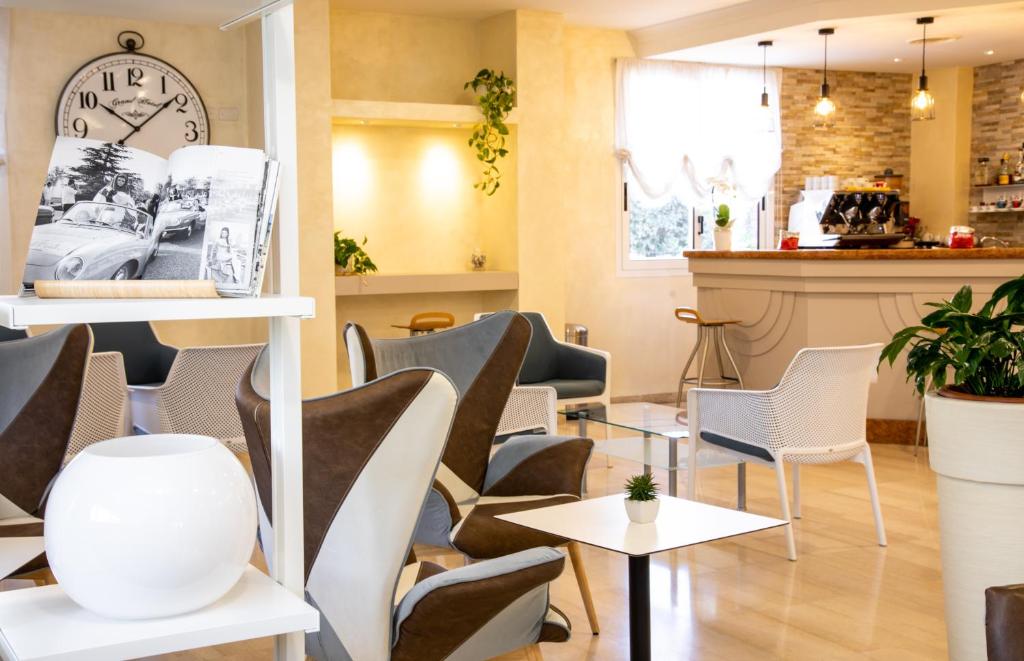 a restaurant with chairs and a clock on the wall at Hotel Venezuela in Lido di Jesolo