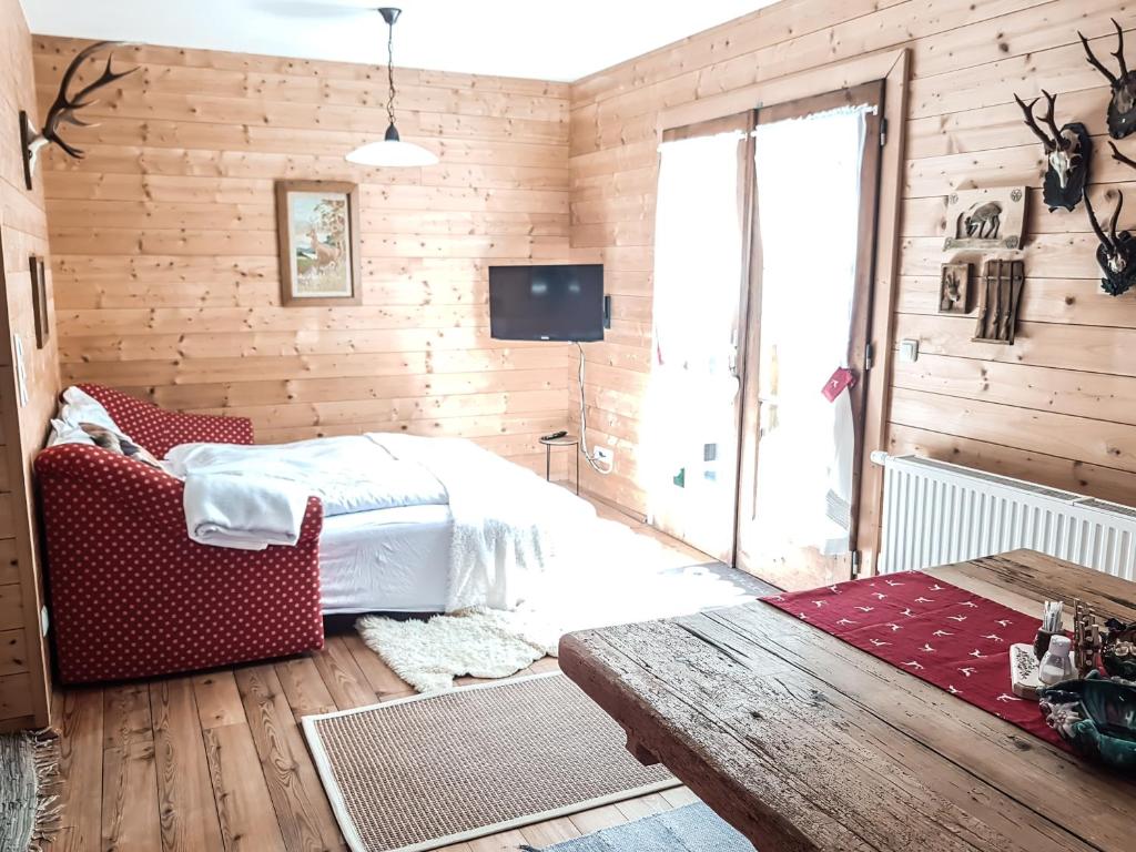 una camera da letto con pareti in legno, un letto e una TV di Weigl Hütte Semmering a Semmering