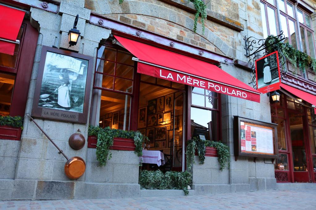 a building with a sign for a la were founded at La Mère Poulard in Le Mont Saint Michel