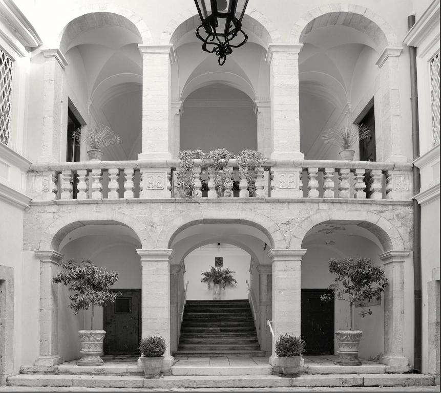 トラーニにあるLa Soffitta Covelliの階段とバルコニー付きの白い大きな建物