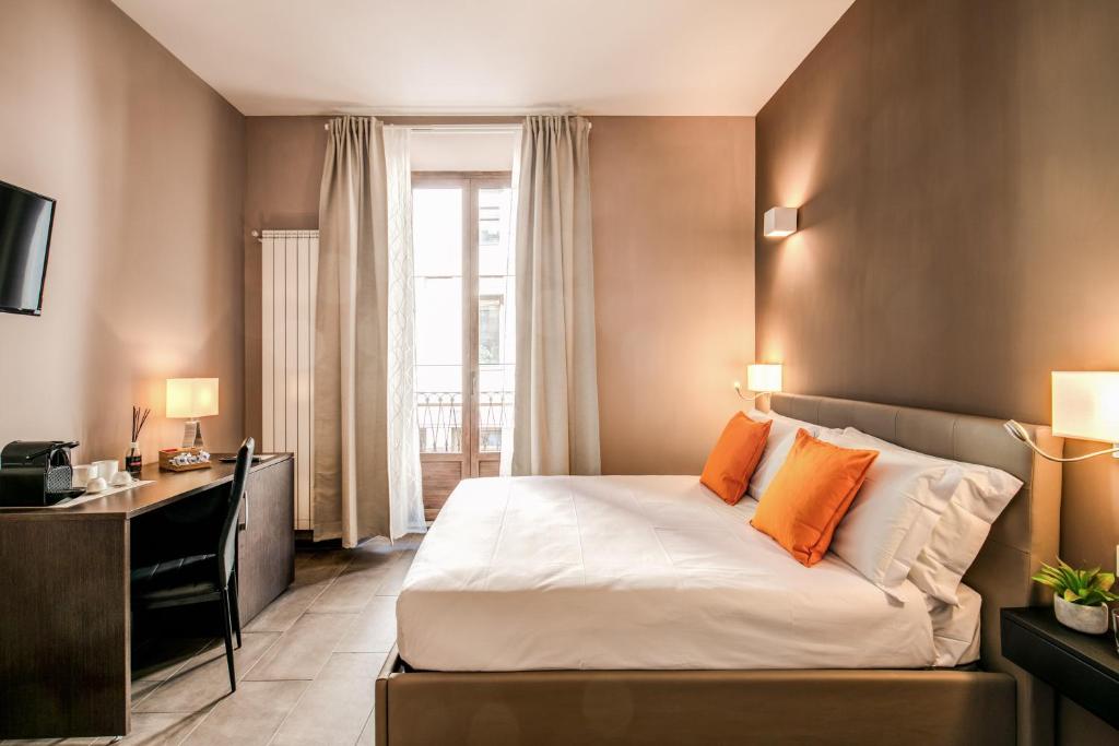 een slaapkamer met een bed, een bureau en een raam bij H501 Luxury Rooms in Rome