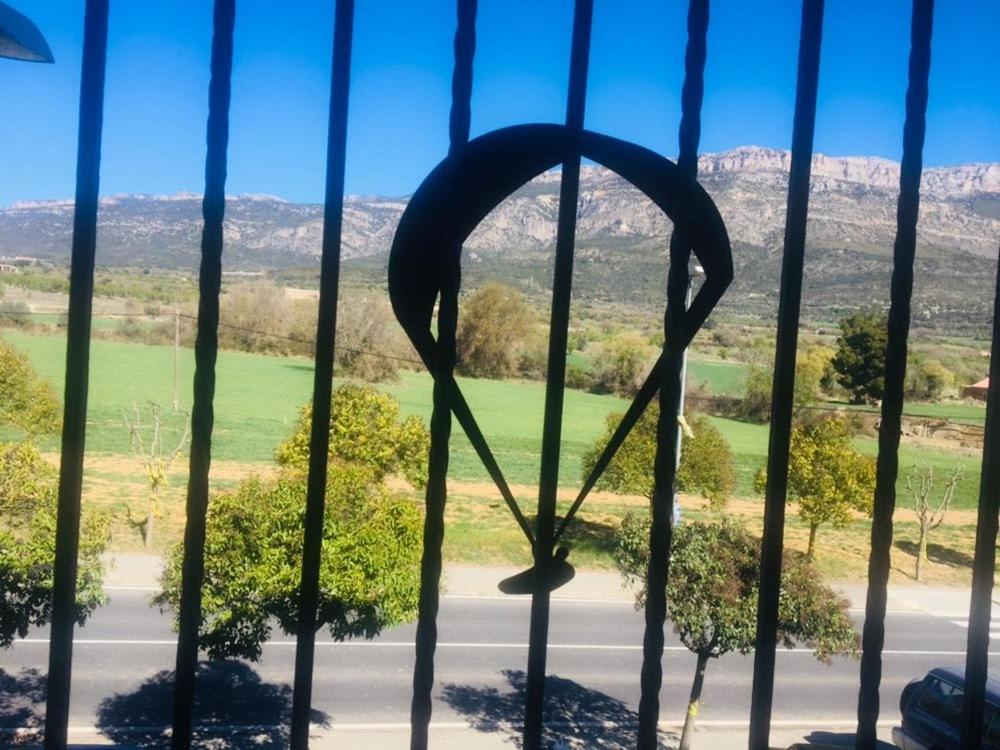 a window with a view of a field and mountains at Apartament Vall d'Àger II in Ager