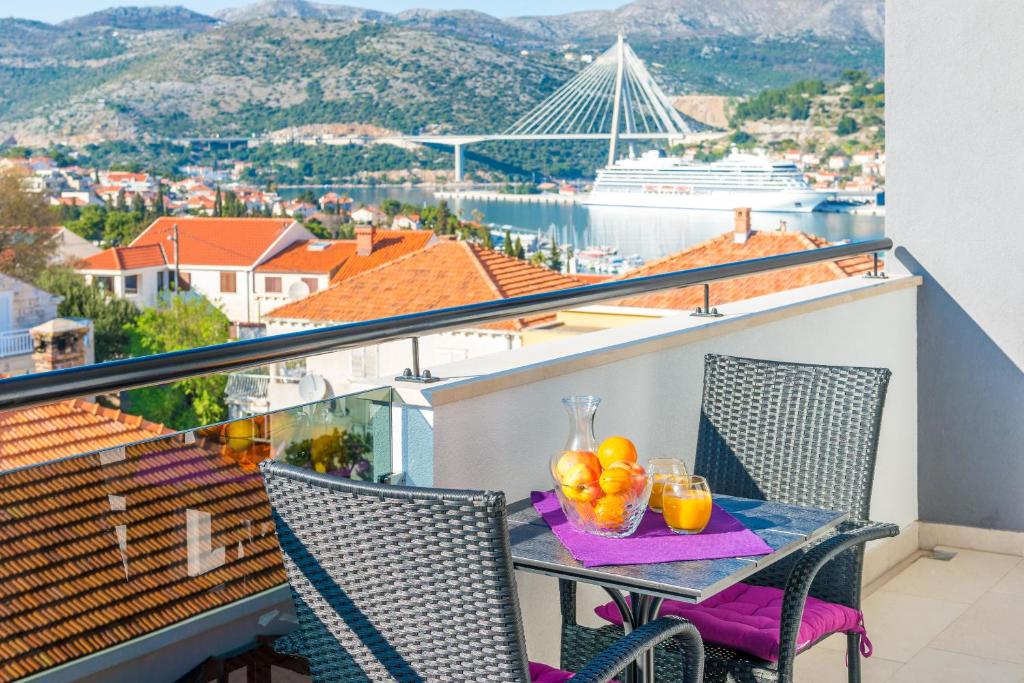 - une table avec des fruits sur un balcon avec vue sur un navire dans l'établissement Apartment MaLa, à Dubrovnik