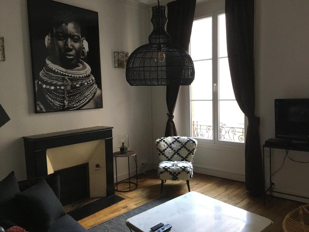 a living room with a fireplace and a chair at Appartement Lanjuinais in Rennes