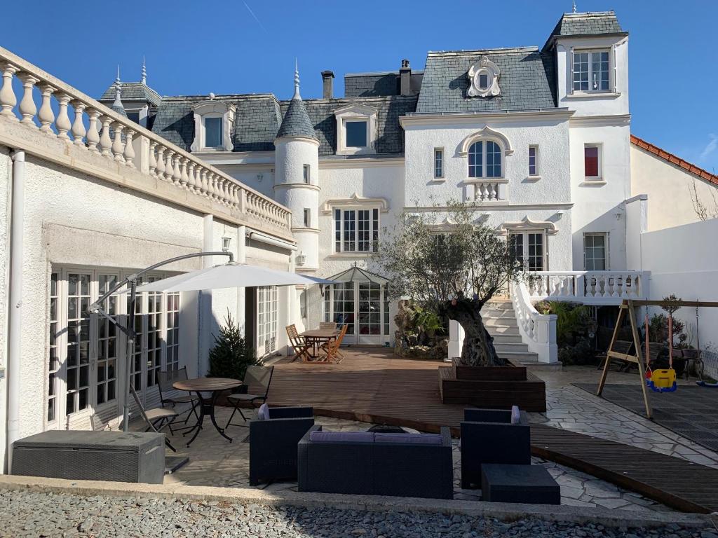 a house with a courtyard with a table and chairs at Villa Florian in Neuilly-Plaisance