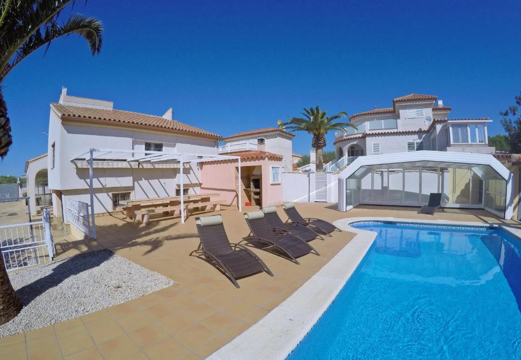 een villa met een zwembad en een huis bij La Palmera in L'Ampolla