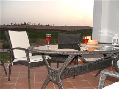 una mesa y sillas con copas de vino en el patio en Condado de Alhama PH1502, en Alhama de Murcia