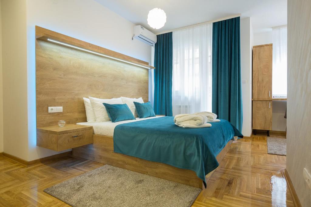 sypialnia z łóżkiem z niebieską kołdrą w obiekcie Thomas Residence w Belgradzie
