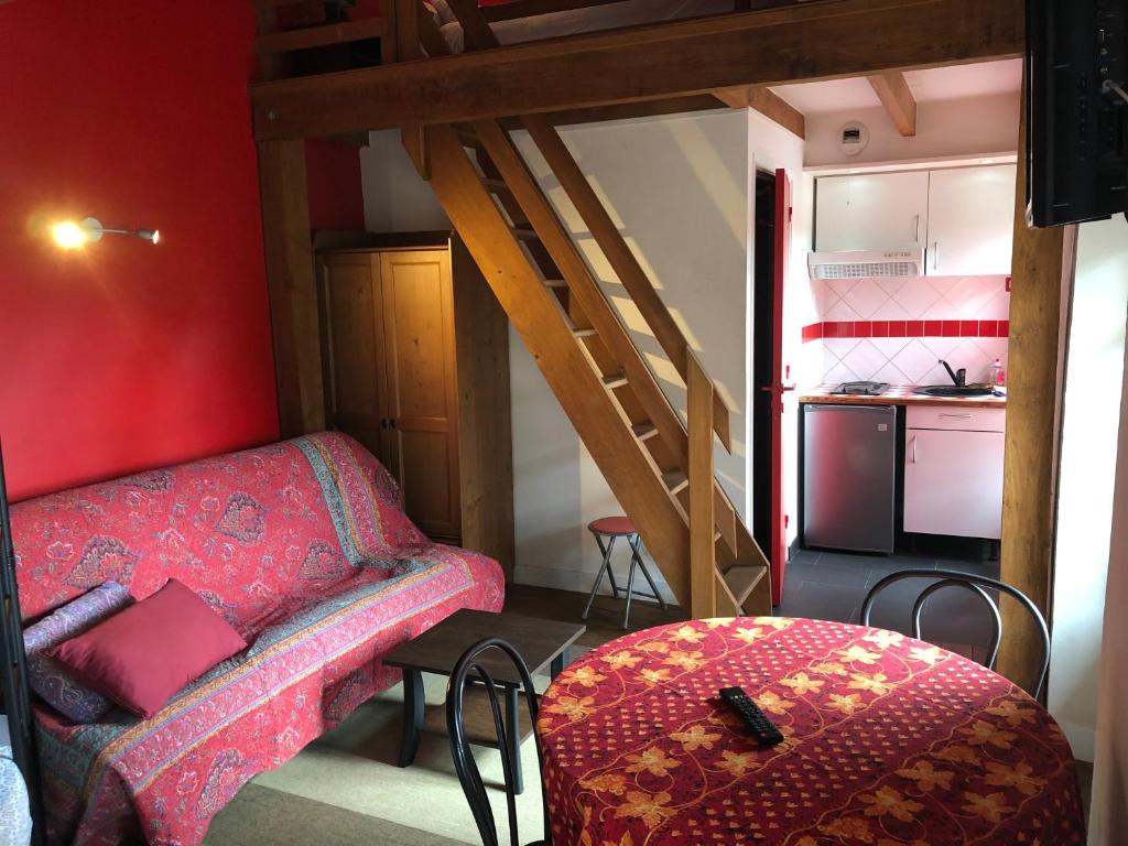 a small room with a bed and a staircase at Appartements et Chambres Le Vaumurier de Saint Lambert in Saint-Lambert