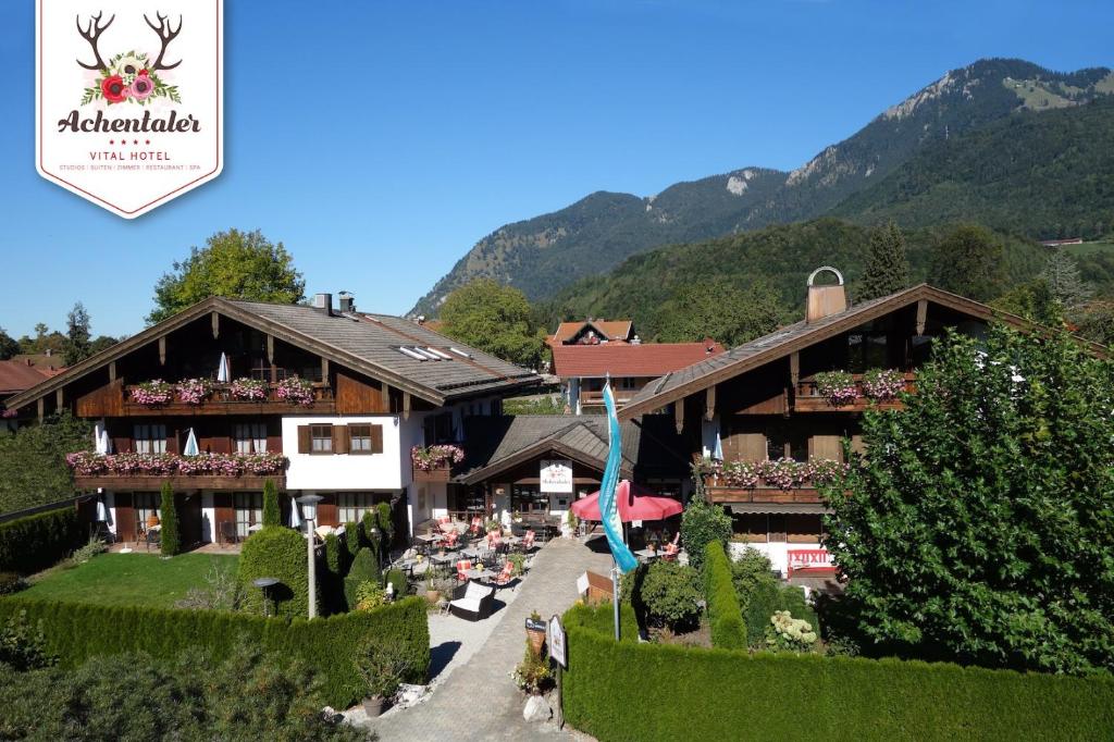 a hotel with a garden and a mountain in the background at DEVA Achentaler Vitalhotel in Unterwössen