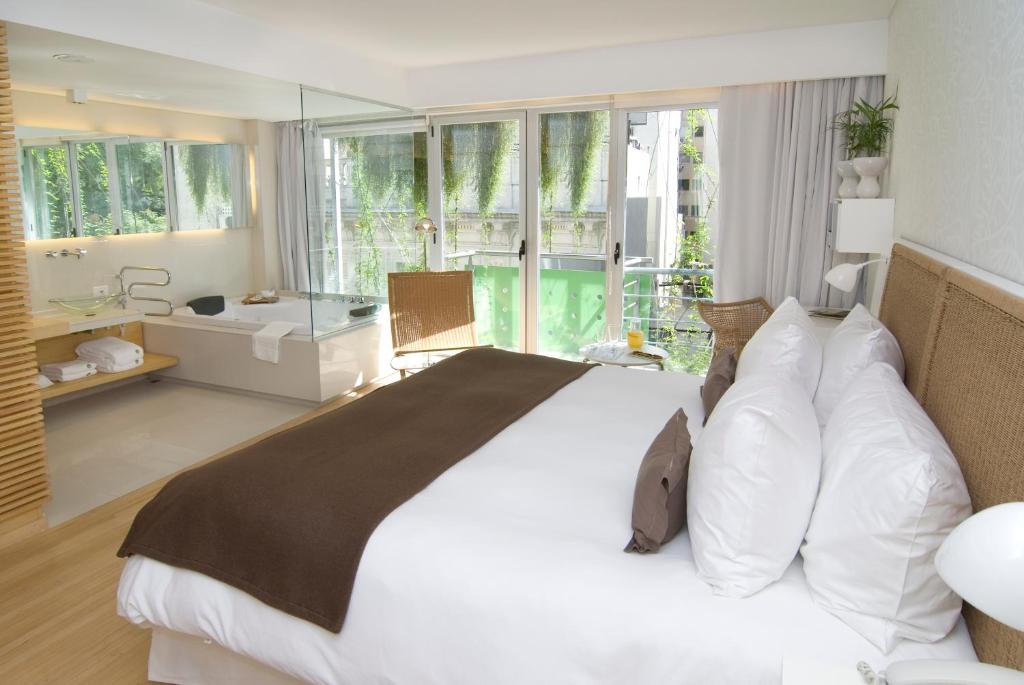 duża sypialnia z dużym łóżkiem i łazienką w obiekcie CasaCalma Hotel w BuenosAires