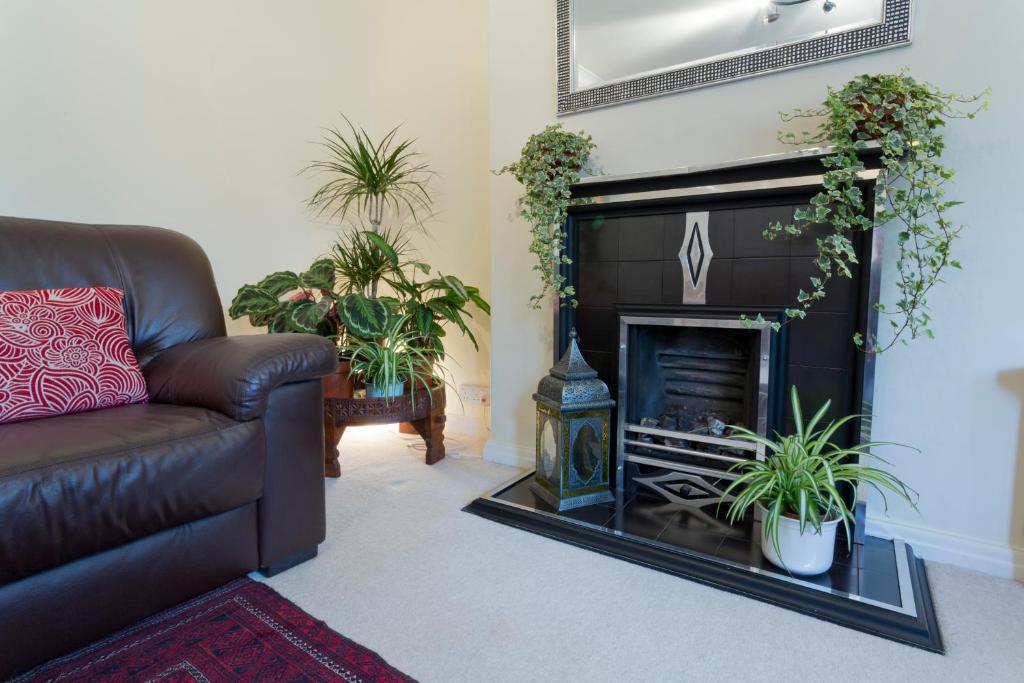 sala de estar con sofá y chimenea en Poplar House Serviced Apartments, en York